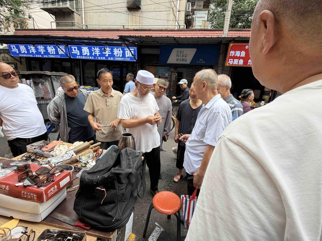 今天上午，我逛西安档子，在西仓东巷，看到修眼镜的摊子，围满顾客，就停下脚步观看。