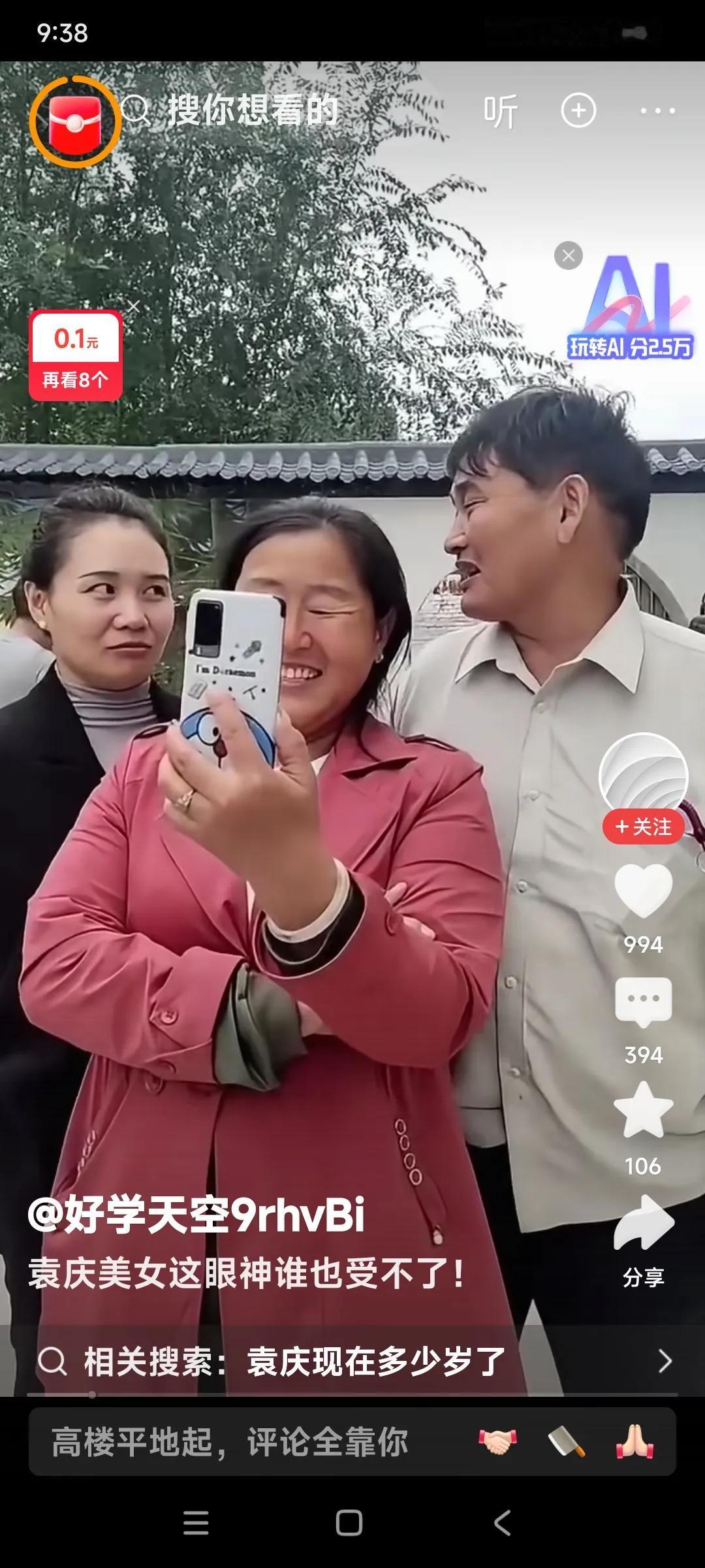 大衣嫂傻笑着在看着手机。袁庆和大衣哥在大衣嫂身后边儿，也在看大衣嫂的手机。