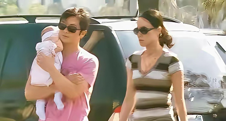 当年，李亚鹏抱着刚做完手术的李嫣与妻子王菲走在北京街头时的一幕