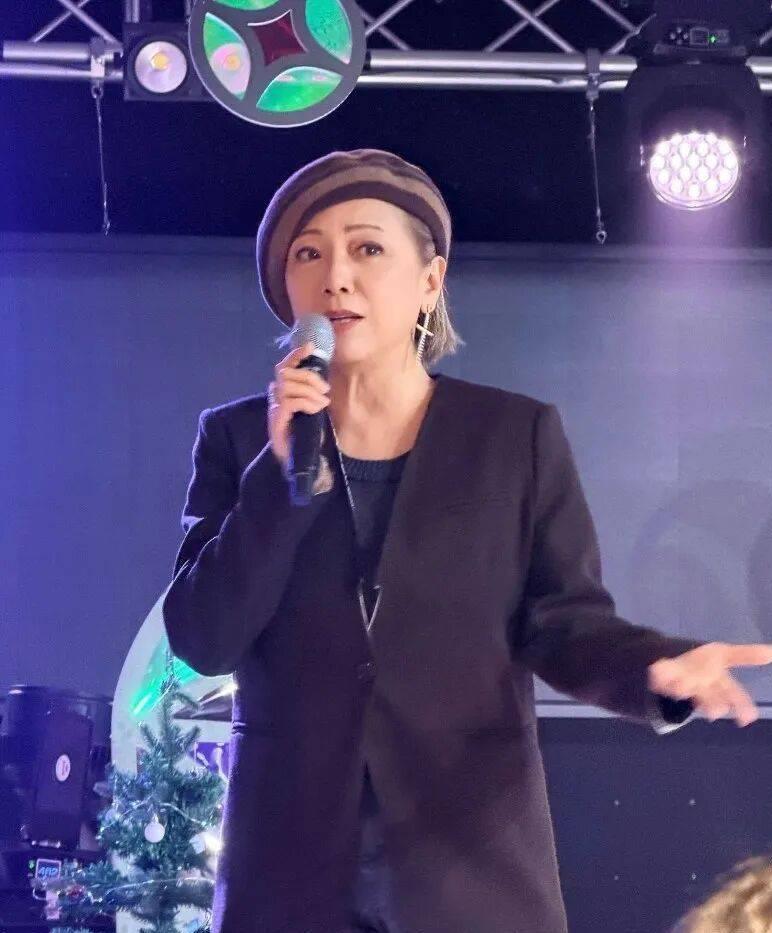 59岁的邓萃雯戴上画家帽，穿着棕色西装外套站在香港分享会的讲台上，脸色红润得像吃