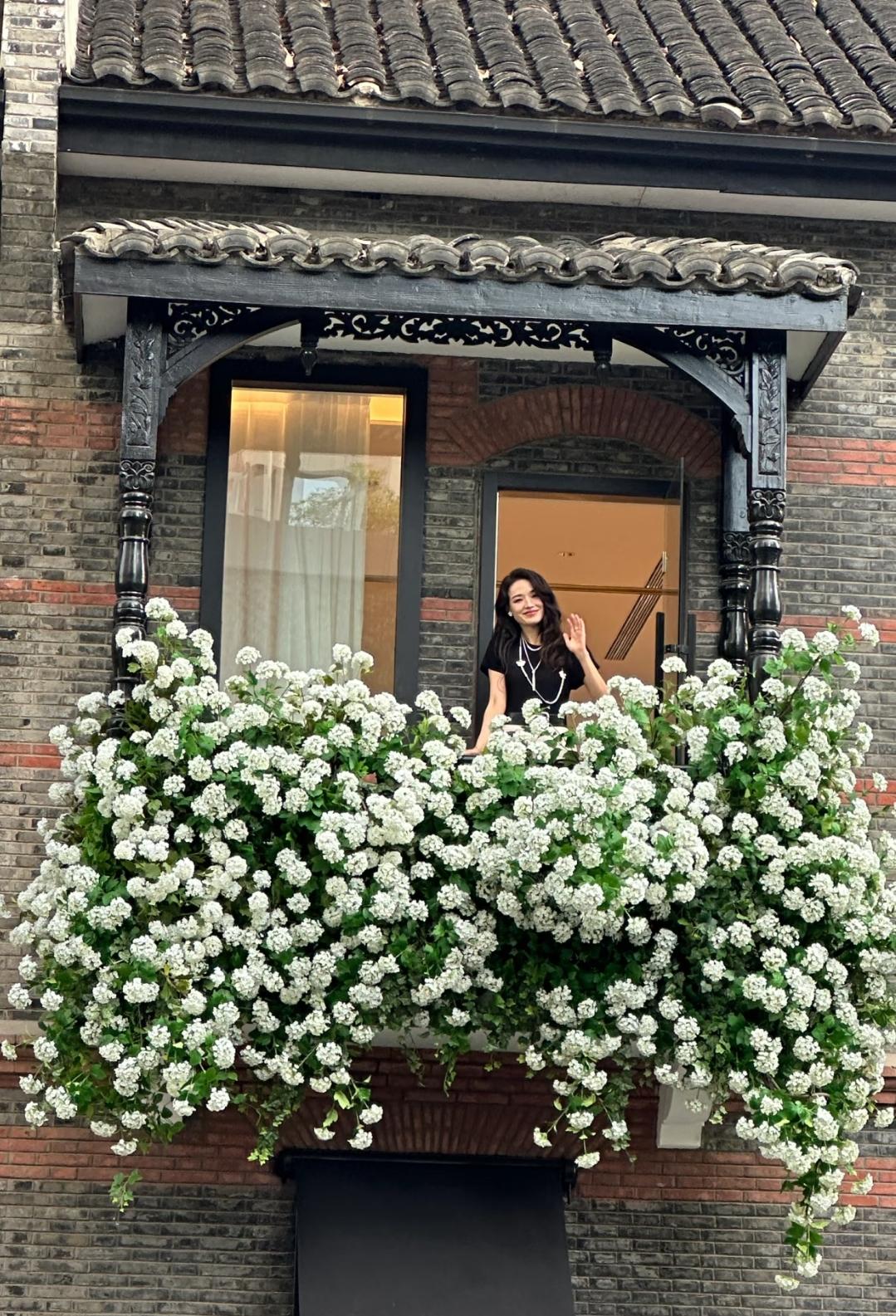 撞见舒淇藏在满墙白花里挥手的瞬间，直接魂穿偶像剧名场面！老洋房的雕花阳台裹满了簇