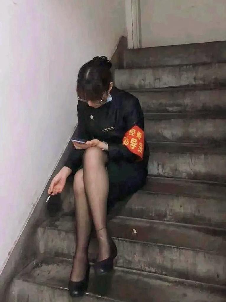今天在朋友圈看到这张图，群里直接吵翻了！戴着“控烟劝导员”的红袖章，自己却在楼
