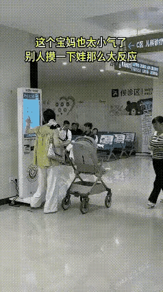 小姐姐带孩子来医院看病，当她在取号机取号时，一位大妈瞧见婴儿车上的孩子很可爱，于