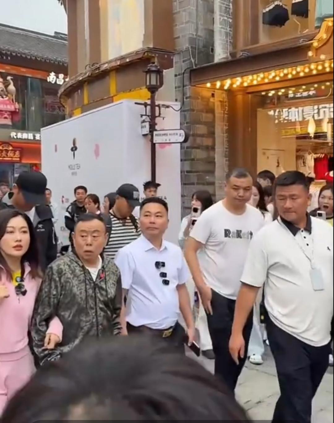 女儿潘阳带着老父亲潘长江现身南昌万寿宫历史街区。潘长江边走边伸手指向街边商铺，