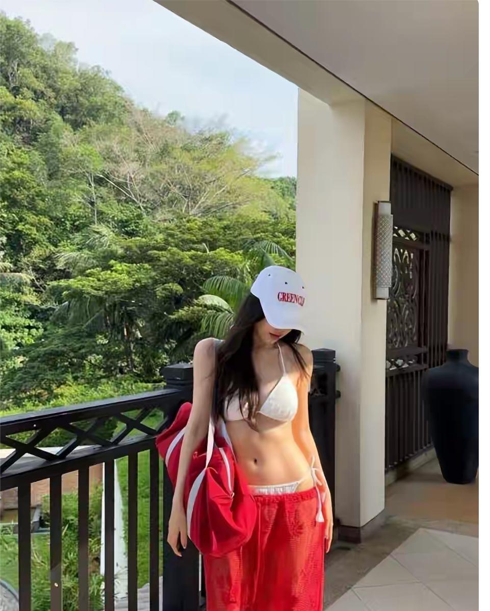 韩国笑星朴圣光妻子晒度假照，她身穿白色比基尼配透视红色长裤，长发飘飘，戴着白色棒