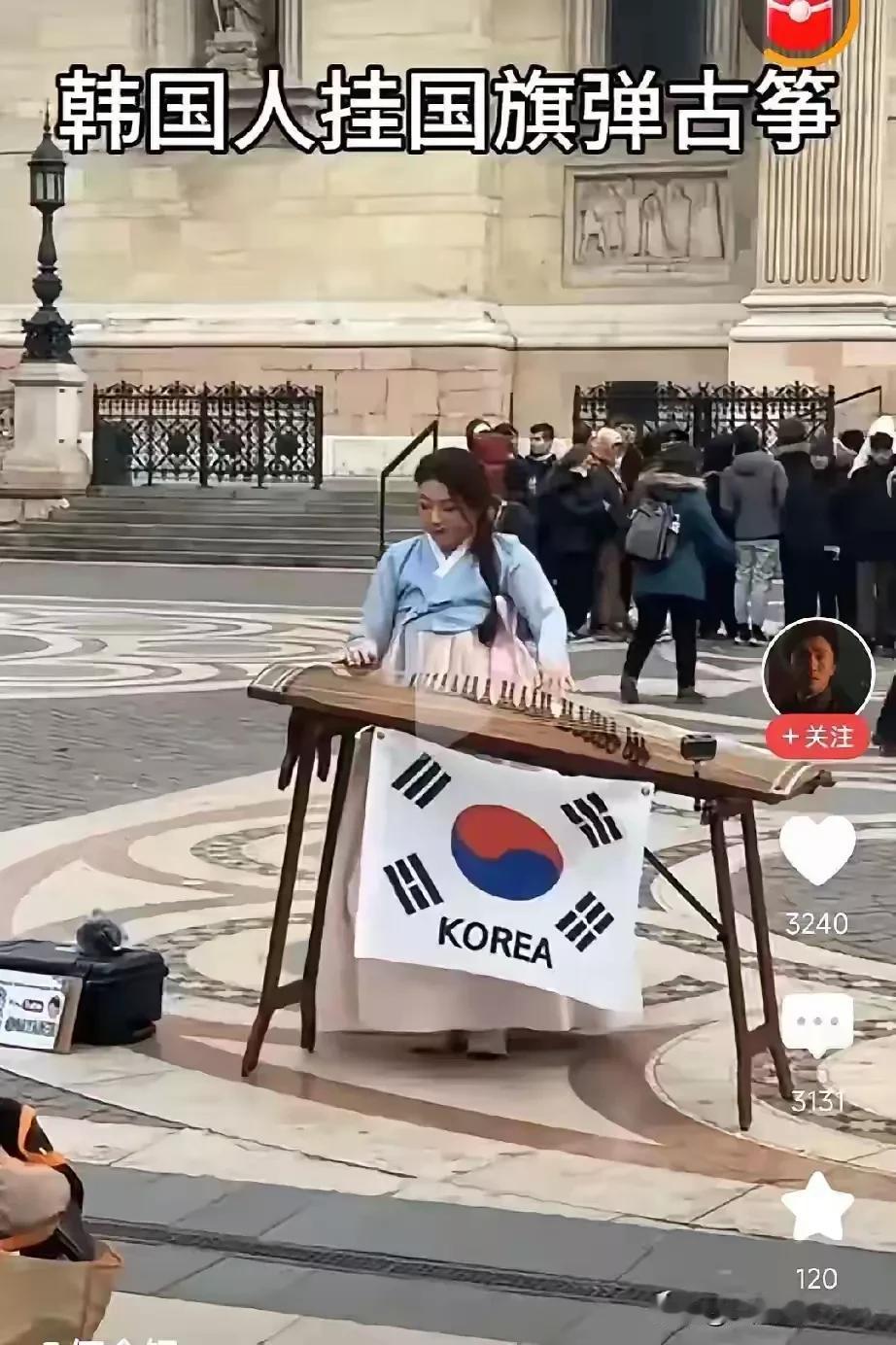 韩国人又对中国古代乐器古筝下手了，一名韩国女孩在英国伦敦街头表演古筝却挂了一面韩