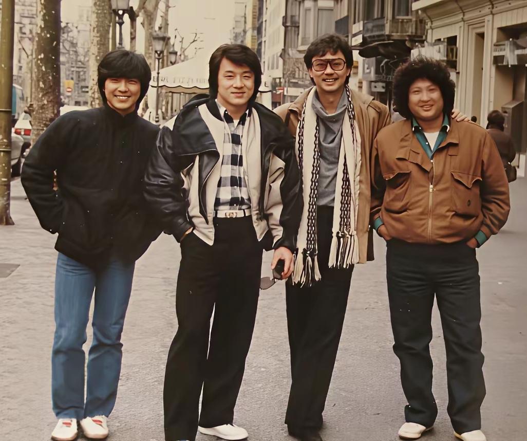 照片中站在成龙和洪金宝中间戴眼镜的男子是谁呀，作为一个70后的人，当年港片没少看