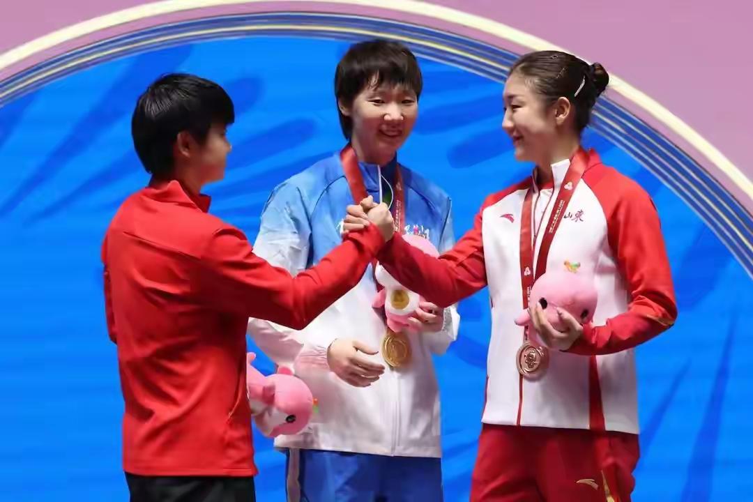 见证中国女乒历史性的时刻：女单颁奖台上，三位国乒姑娘都在笑冠军曼昱，站在中间