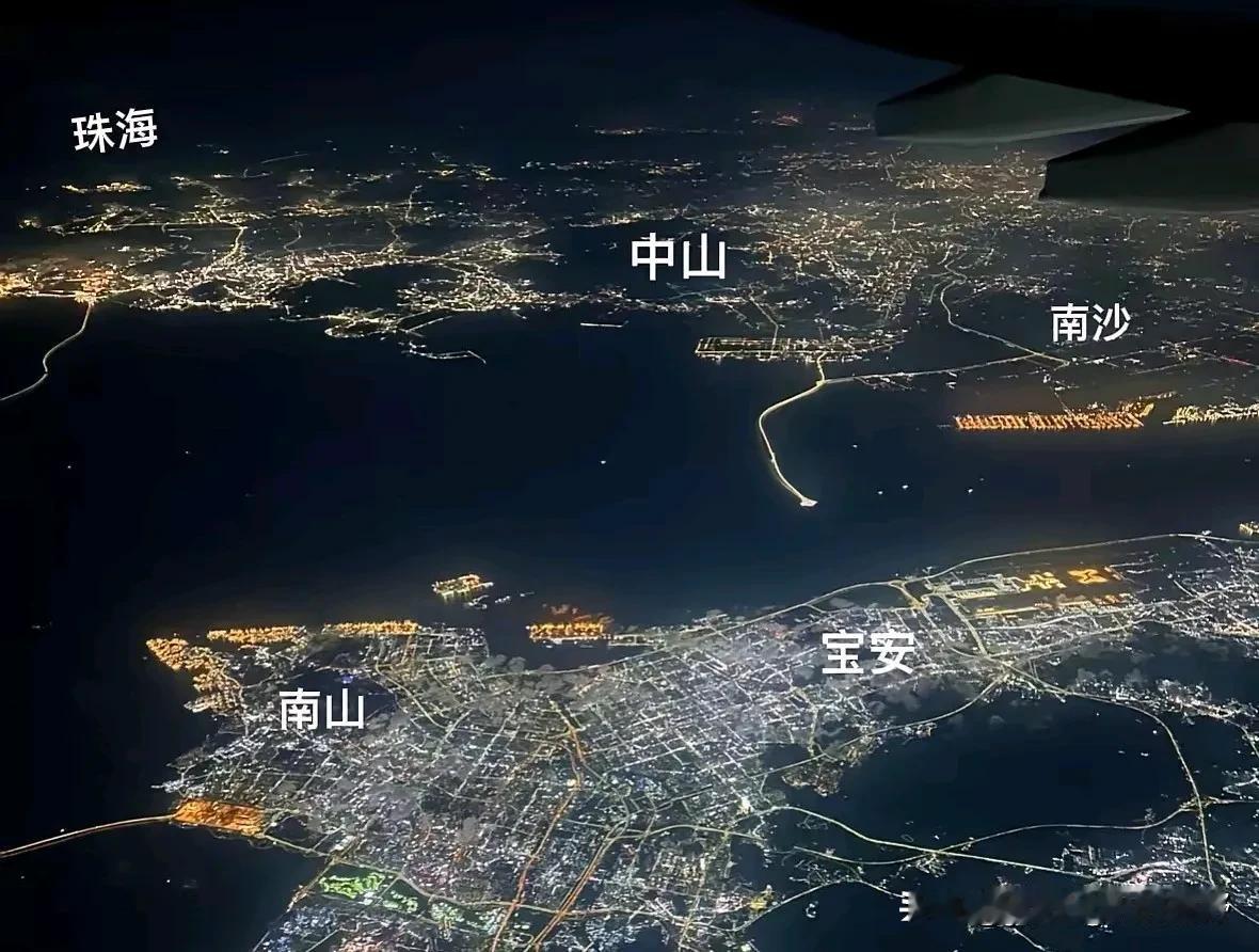夜晚飞机视野下的珠江口两岸。从高空看下去，深圳的南山、宝安地面雪亮一片，对面的中