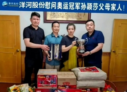 莎莎捧着奖杯跟爸妈合影，脑袋还没奖杯大，萌得不行！一家子小圆脸，基因这东西真没话