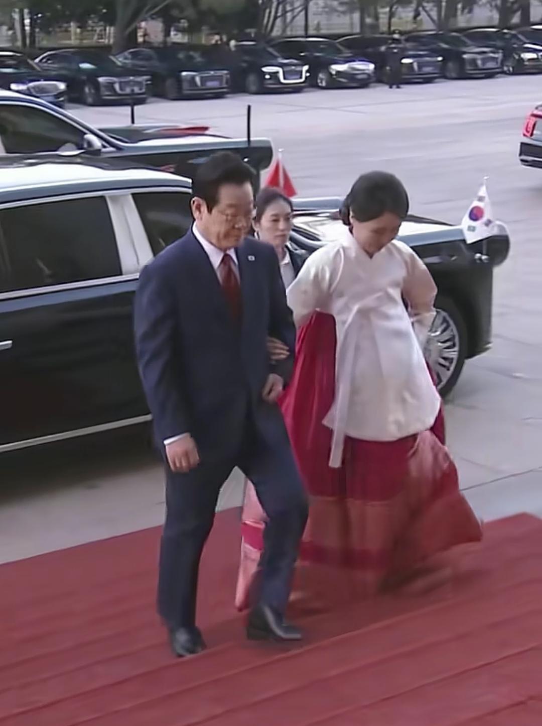 红裙白上衣，脚步踩在人民大会堂红毯上。金惠景第一次穿韩服亮相中国外交场，之前全