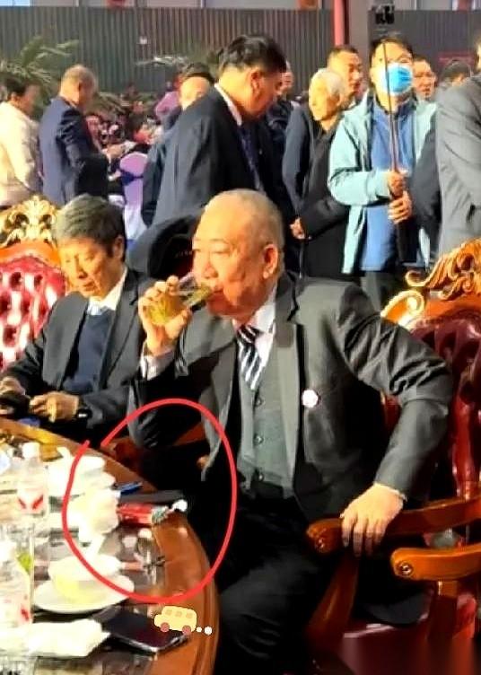 崔培军的年会，一桌子人，镜头就对着他手上。手指间夹着一根烟，红色的软盒就扔在桌