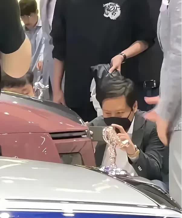雷军逛展和别人不一样车展人群挤在劳斯莱斯展台前拍车模，雷军举着手机对准了车门