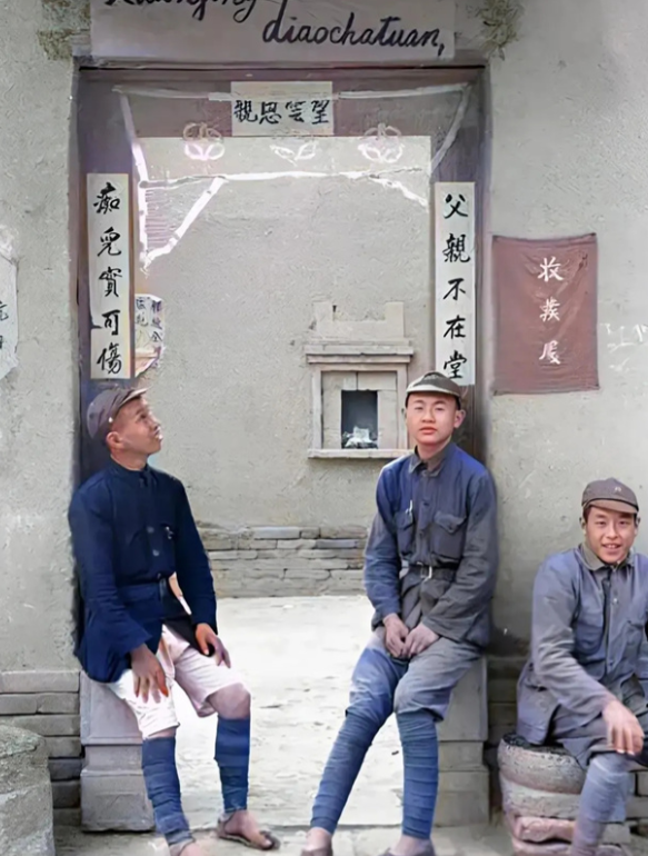 1944年，延安。3名年轻的八路军战士，正坐在院门口的石头上。仔细看照片，你会发