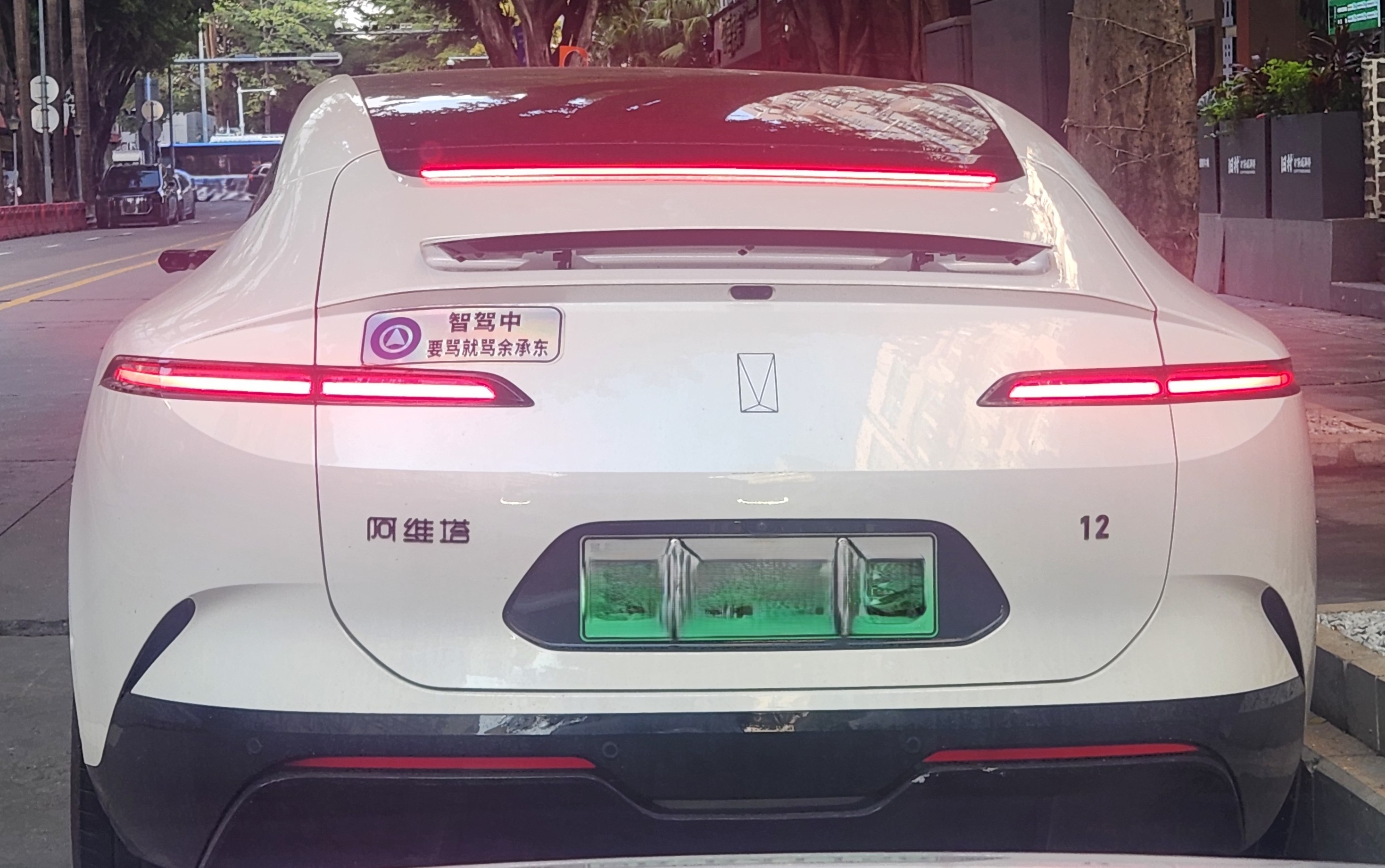 路旁静静停着一部姿态优美的阿维塔12，骄傲的车主用一张小小的贴纸给良好...