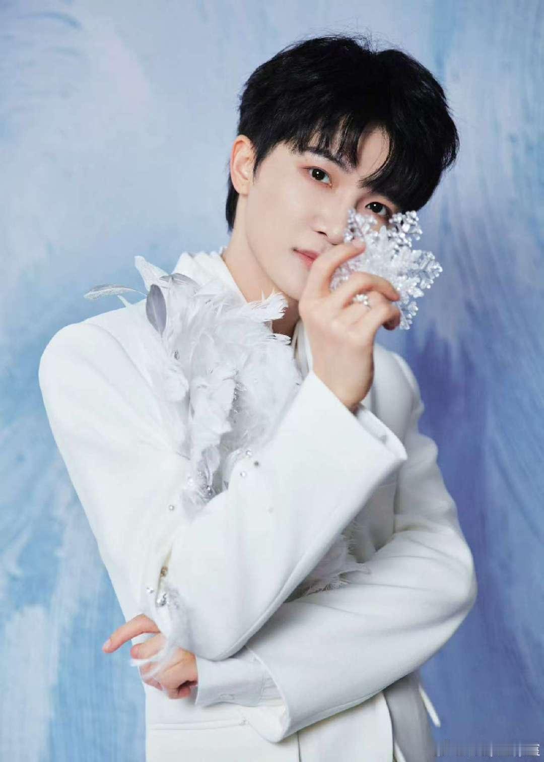 周深把雪花拿在手上周深霜雪凝成西装的纹路周深手持晶莹雪花，一身纯白西装仿佛凝着霜