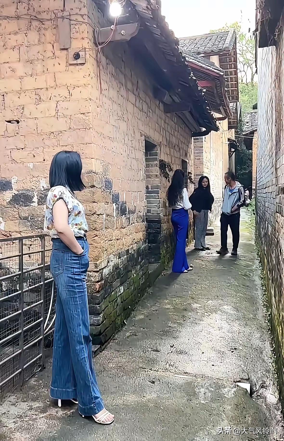 这个地方从建筑造型分析应该是云南或贵州一定的民居风格。这几个人在这巷子里是干嘛