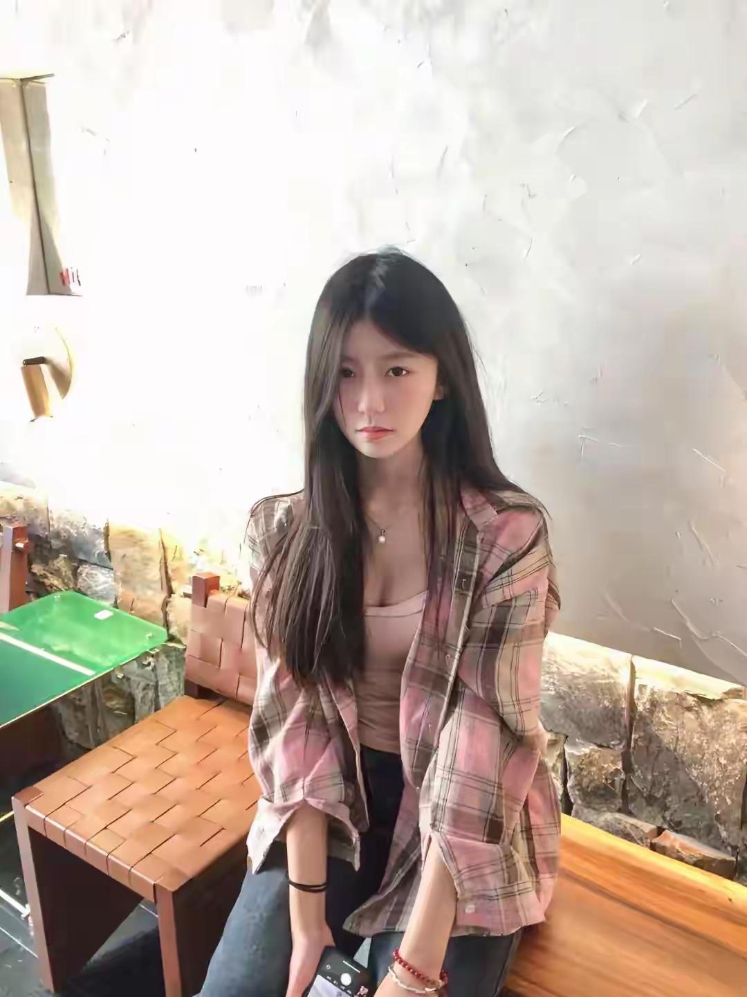 粉调格纹衬衫松松垮垮搭在肩头，内搭浅杏色吊带露出精致锁骨，黑长直的发丝垂落，慵懒