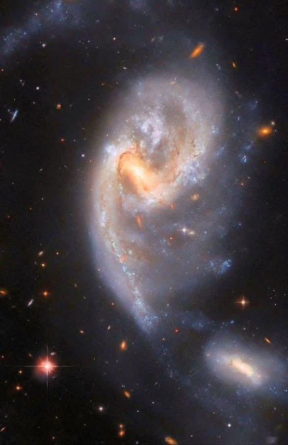 当两个星系靠得太近时会发生什么？在遥远的宇宙深处——距离我们1.6亿光年，在蛇夫