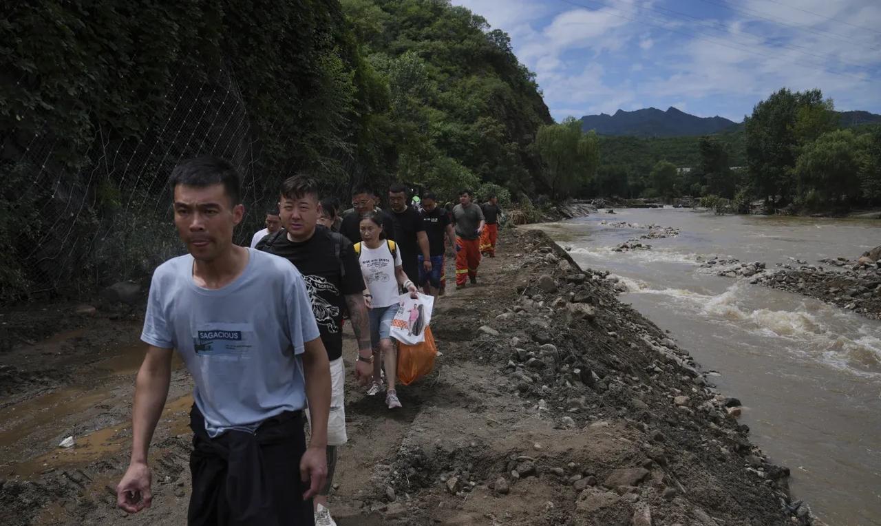 美联社记者用镜头记录下北京密云洪水泛滥成灾，民众紧急响应疏散通知，徒步远离洪灾区