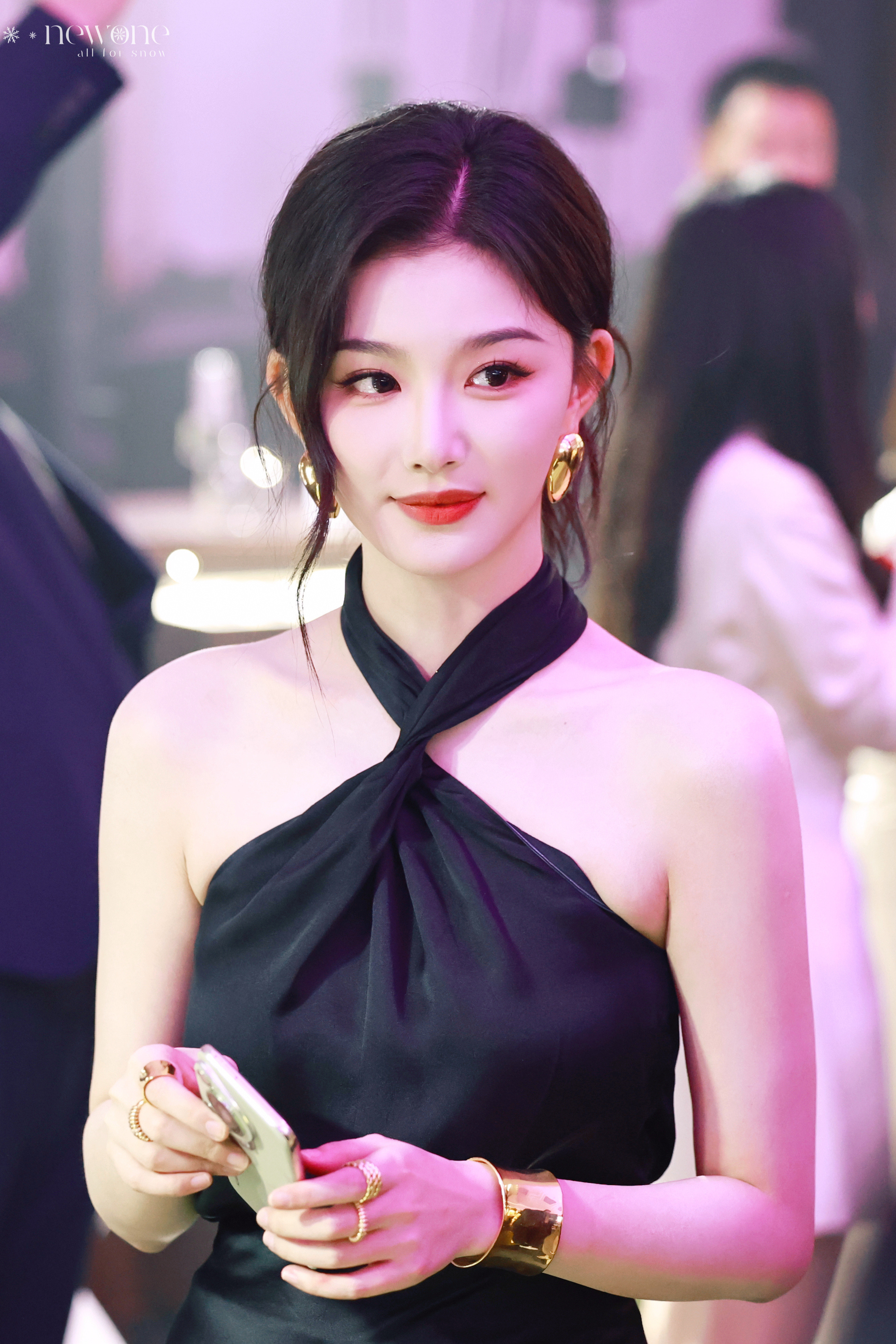 孔雪儿挂脖黑裙衬着肌肤胜雪，侧头抬眸，眼尾的红与唇色相衬，带着一丝漫不经心的温