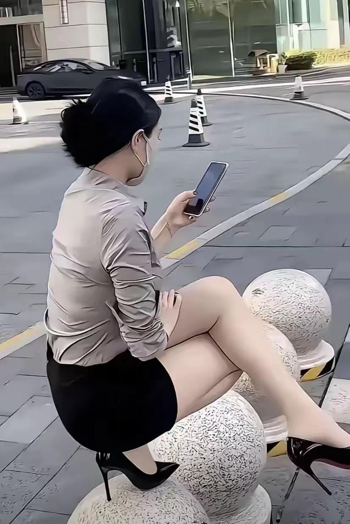 深圳路边那幕太戳人了！女子穿高跟鞋单脚蹲在石墩上，鞋尖悬着、小腿紧绷，手里还攥