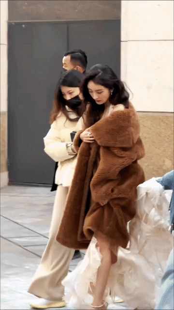 杨幂够敬业，那么冷的天，穿个大衣还露出个肩膀凹造型，可是露肩礼服外面穿大衣不就是