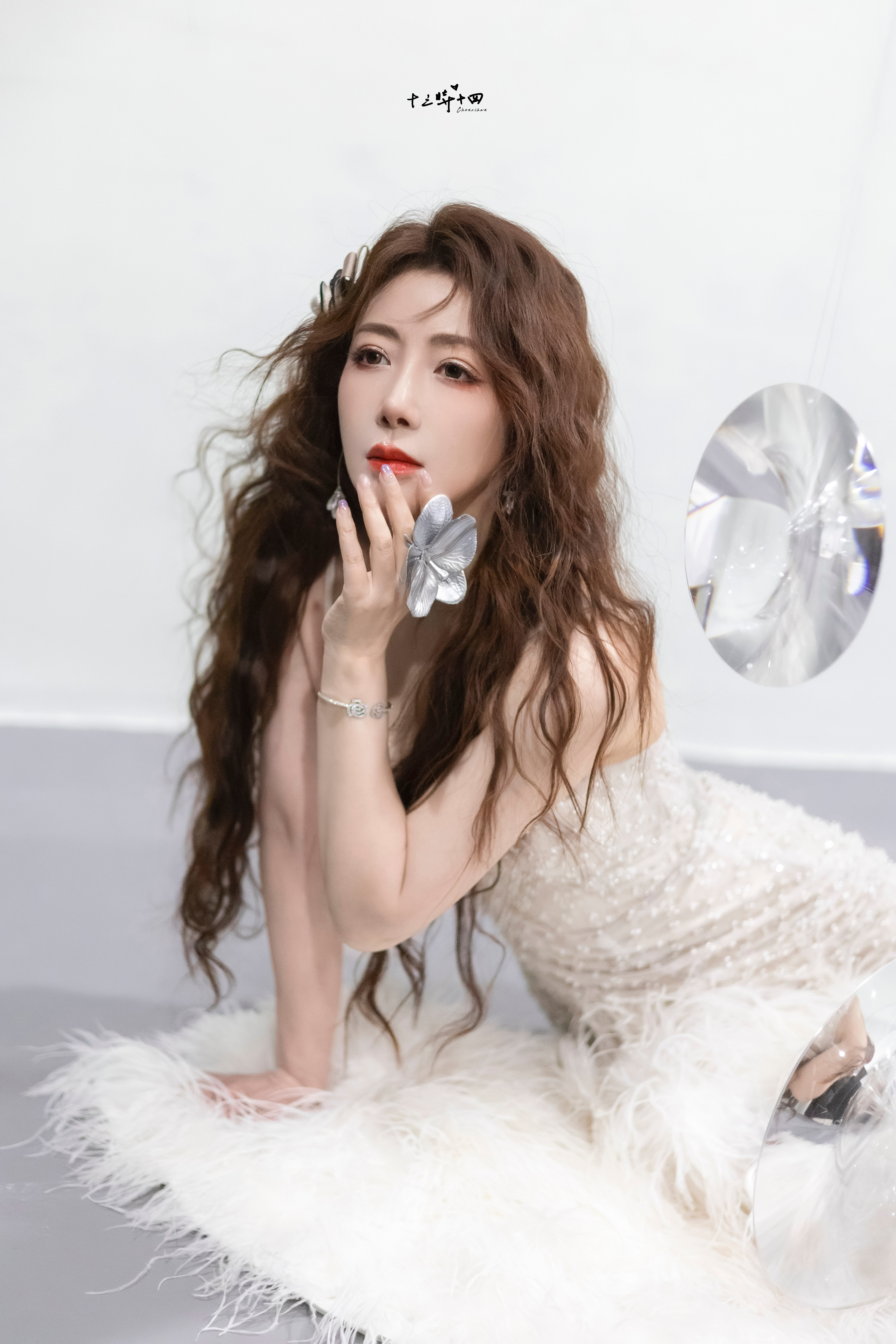 陈紫函身姿曼妙，一袭珠饰礼裙勾勒出玲珑曲线，在柔美白绒与镜面光影间，每一处线条