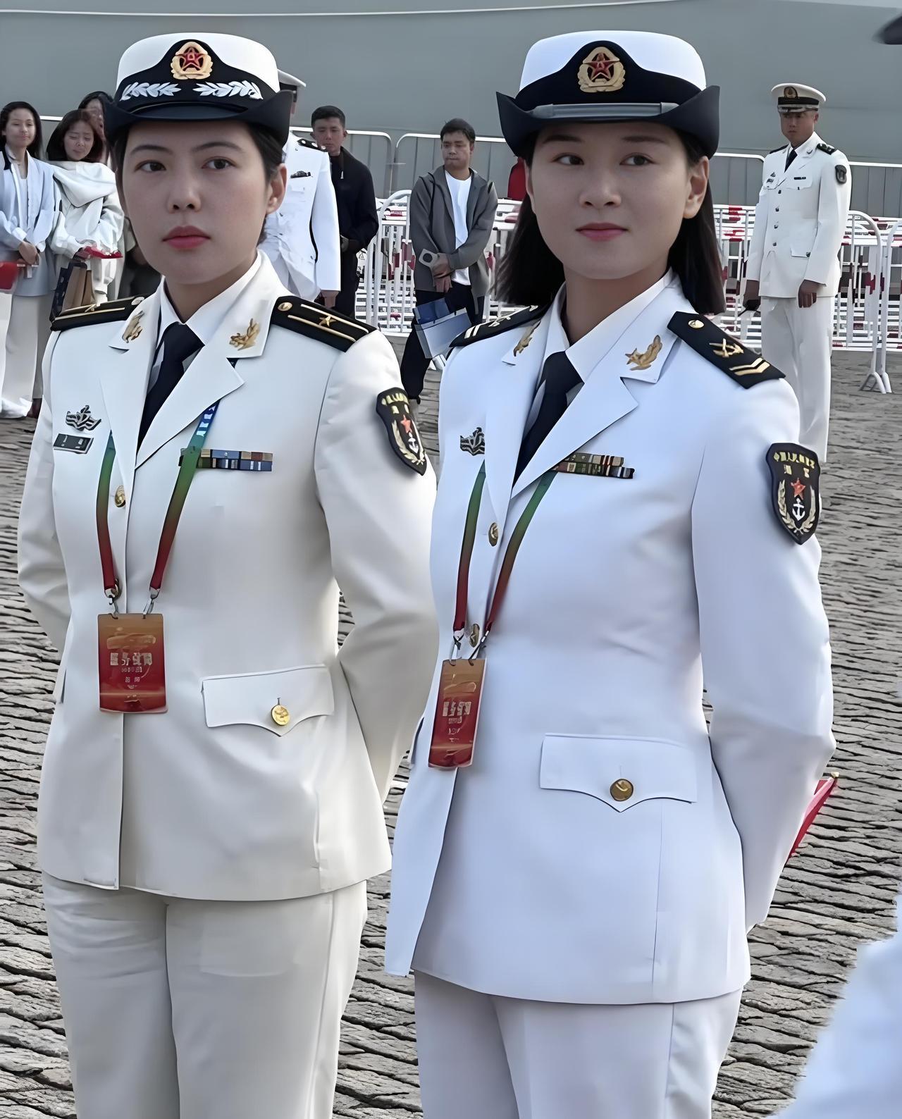 这两个英姿飒爽的海军女兵的服装颜色为什么不一样？左边这位女兵军帽上有麦穗图案，而