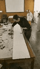 一帮傻子围着一个疯子拍照，都病的不轻。疯子好像在作画，但是他不用笔，他时而用拳