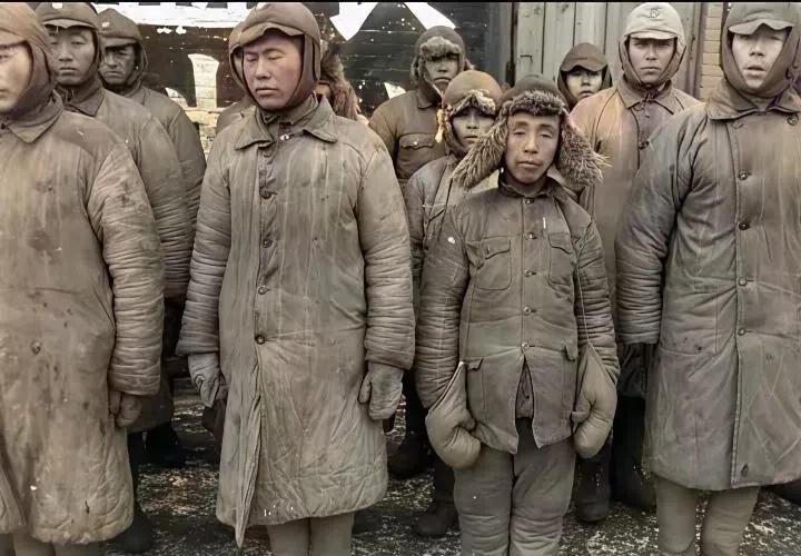 这是一张年代已久、已泛黄的老照片。照片上的士兵们萎靡不振，神情沮丧，穿着沾满油污