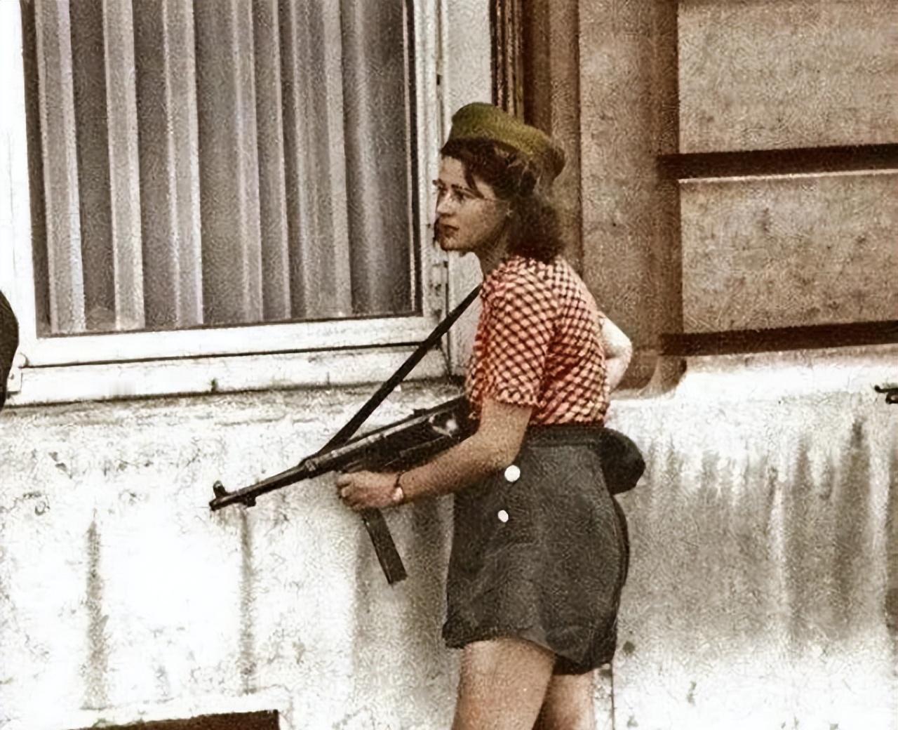 1940年，一个年轻的法国女孩儿，正使用缴获来的冲锋枪与德军作战。她的校服裙