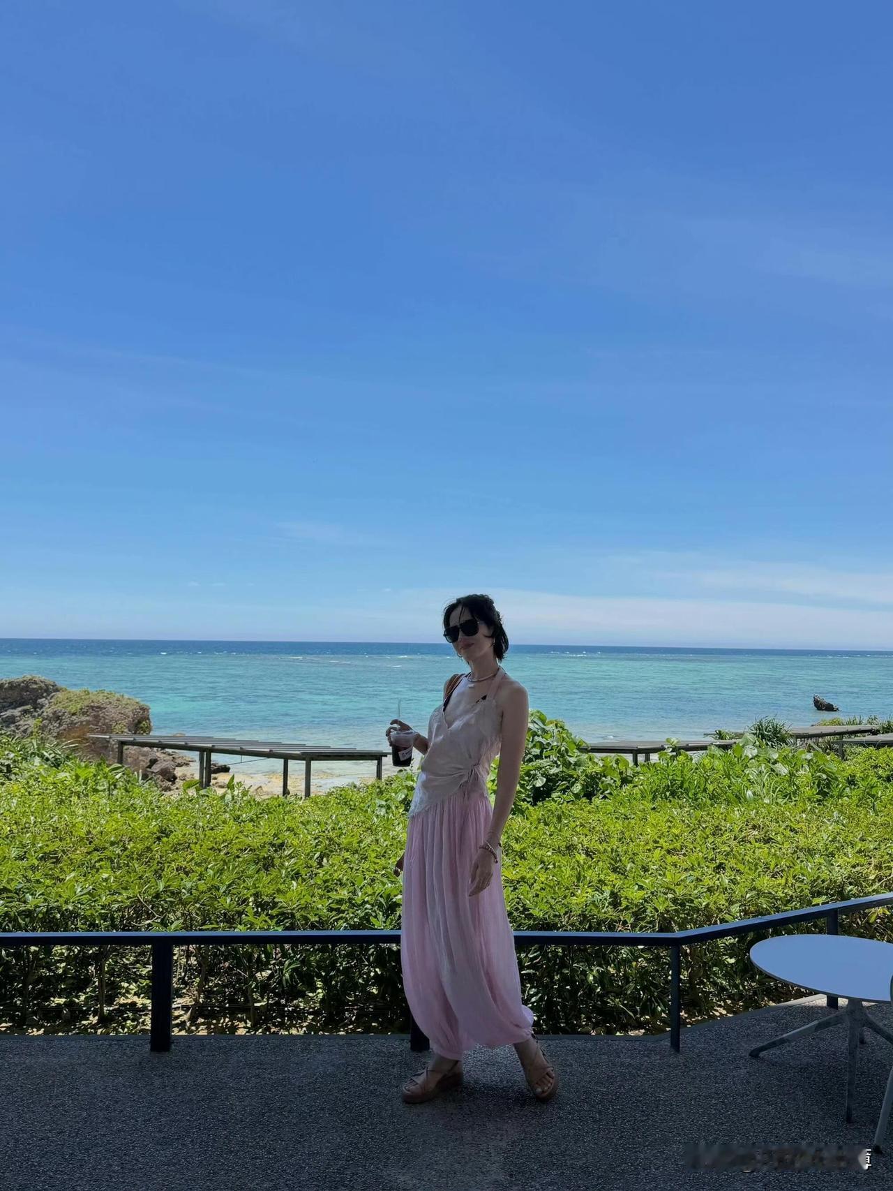 孙艺珍海边度假第3天，蕾丝挂脖背心搭配粉色褶皱长裤，加上随性的编织背包，把海边慵