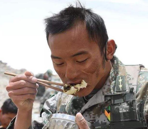 这是一位正在吃饭的解放军战士，他的职责是守卫边疆，看着他饱受风吹日晒的脸庞，真的