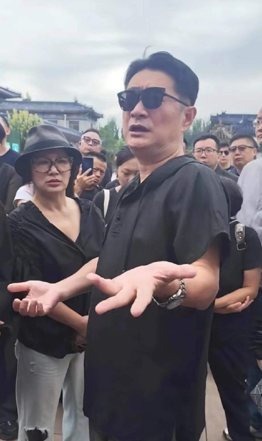 黄安和二婚妻子一起参加了千百惠的葬礼。两个人全部黑色着装，正跟大家交流和讨论关