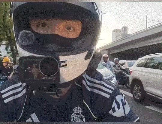 北京，一小伙骑摩托在直行和右转合用车道等红灯，期间就被后方右转车辆一直鸣笛催促。