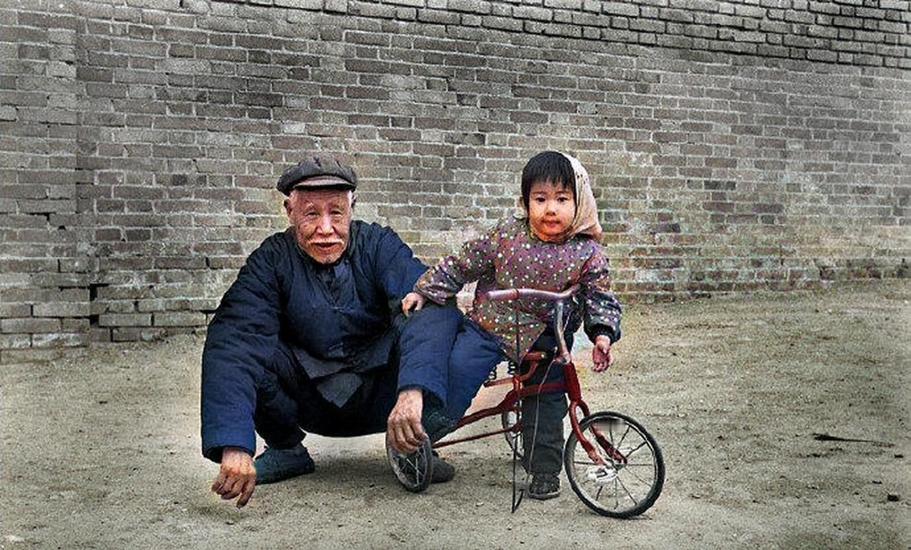 1978年，一个外国摄影师在北京胡同采风，拍到一位带孙女的老大爷。小女孩活泼又可
