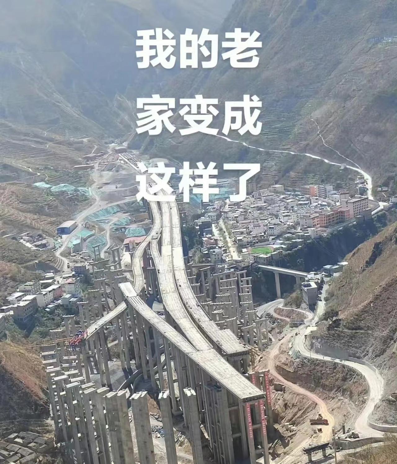 中国西南某贫困县城山谷中正在建设的大型多层高速公路汇集枢纽高架桥的航拍照片。这