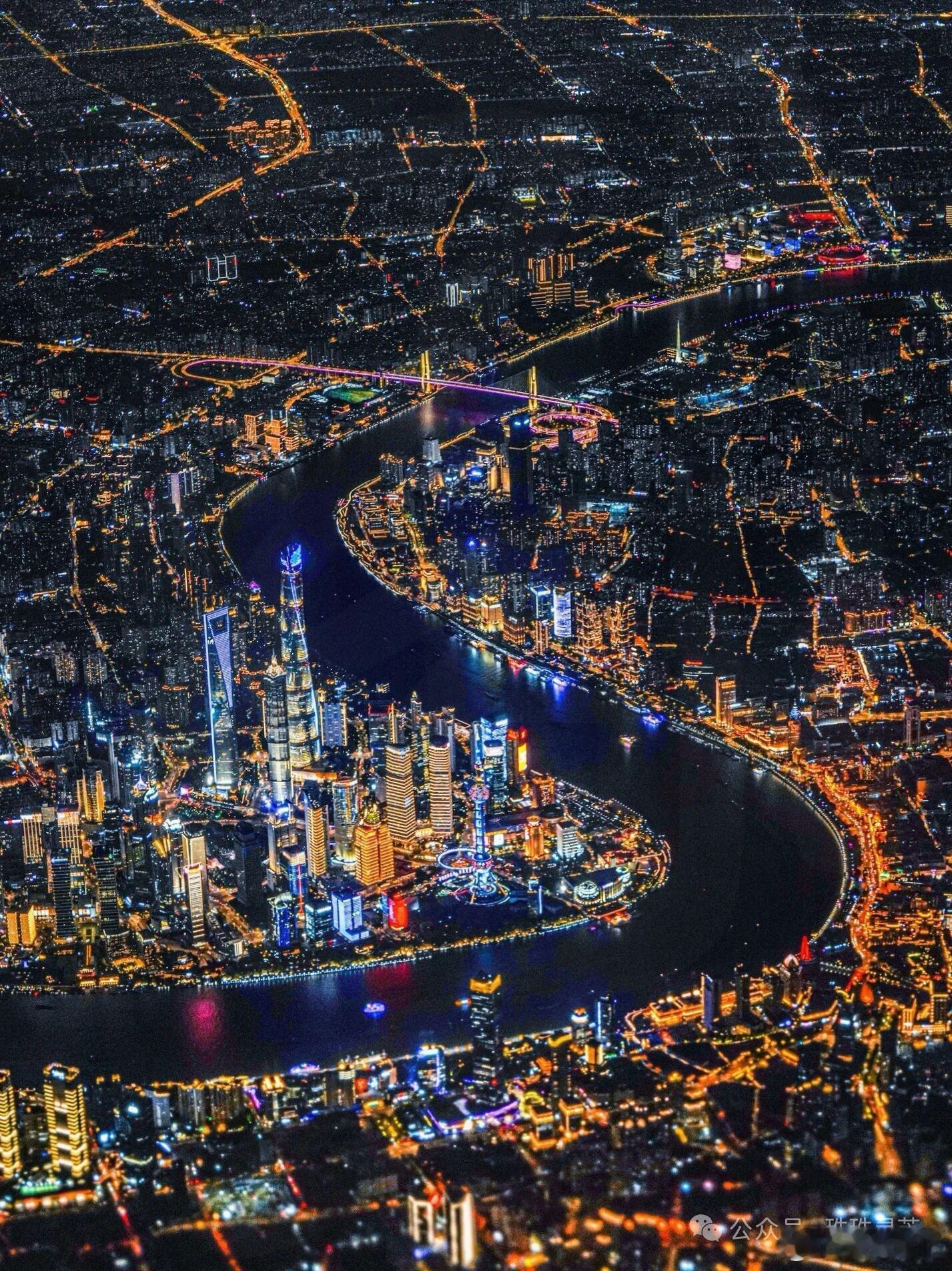 华灯初上，黄浦江蜿蜒如带，陆家嘴的摩天楼群点亮夜的脉搏，千万盏灯汇成流动的星河，