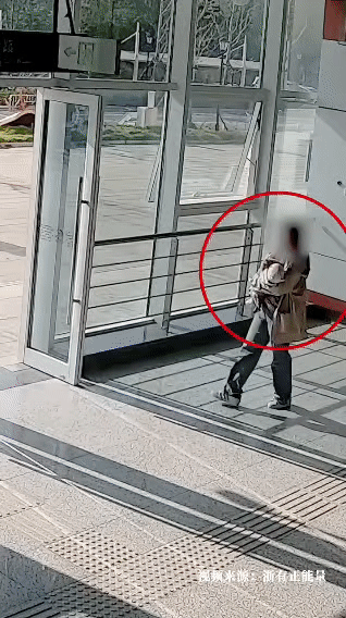 在浙江义乌的轻轨站出站口，一位宝妈蹲坐在地上给怀里的婴儿喂奶。值班辅警龚英强例行