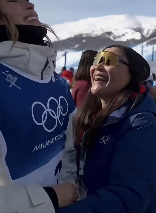 女儿跑过来拥抱时谷燕强忍悲痛用笑脸迎接。谷爱凌在米兰冬奥会拿了金牌，开心地冲