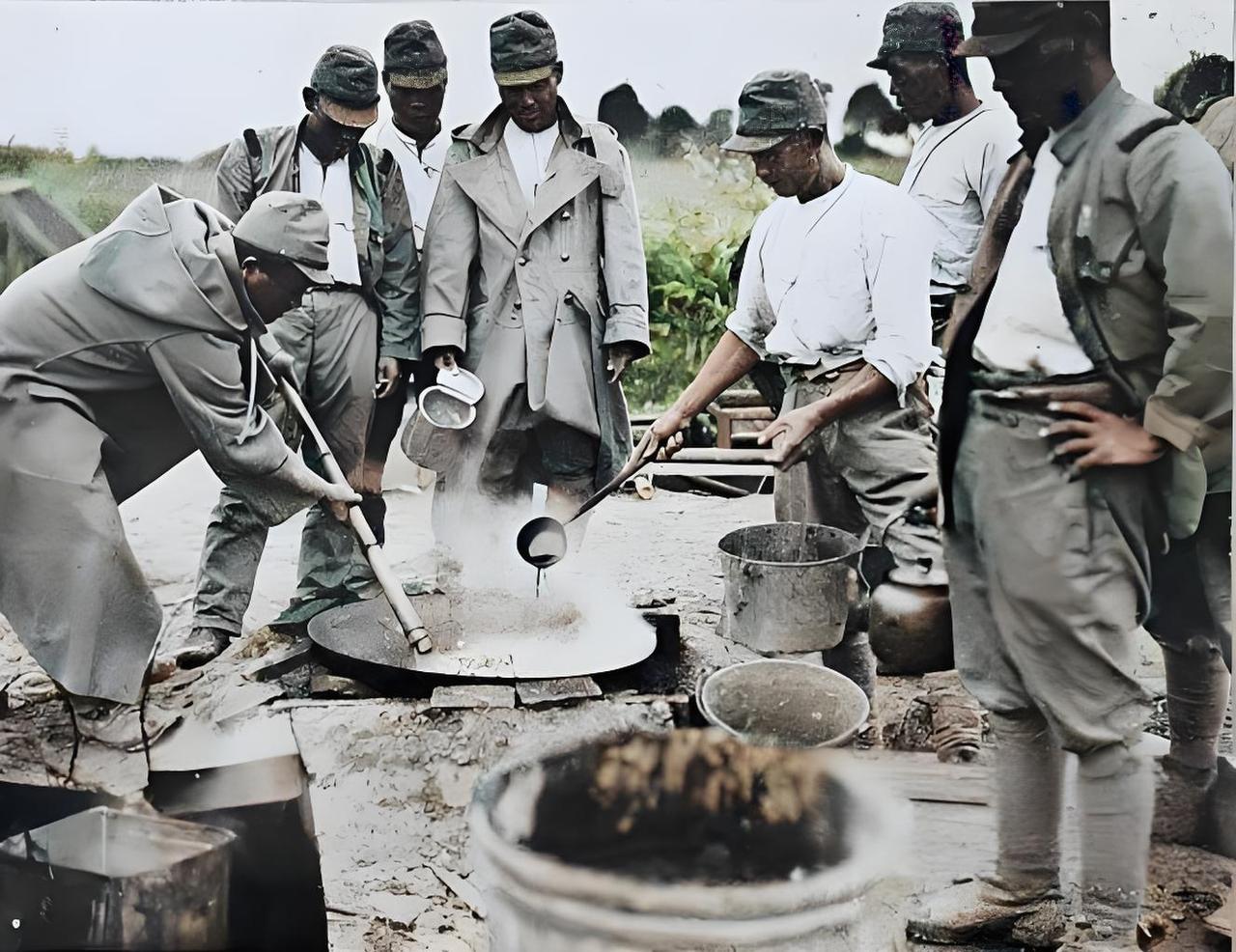 这张1937年淞沪会战时期的老照片，画面中，一群日军士兵聚集在一起，有的弯着腰用