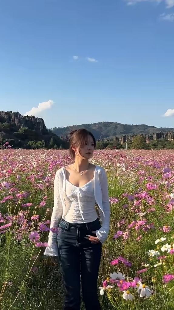 女孩到花海游玩看到美景留连往返。