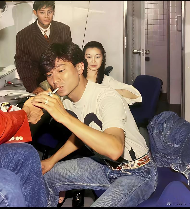 90年代，演出间隙后台休息。工作人员给刘德华点烟时的场景，这是一张非常罕见的后台