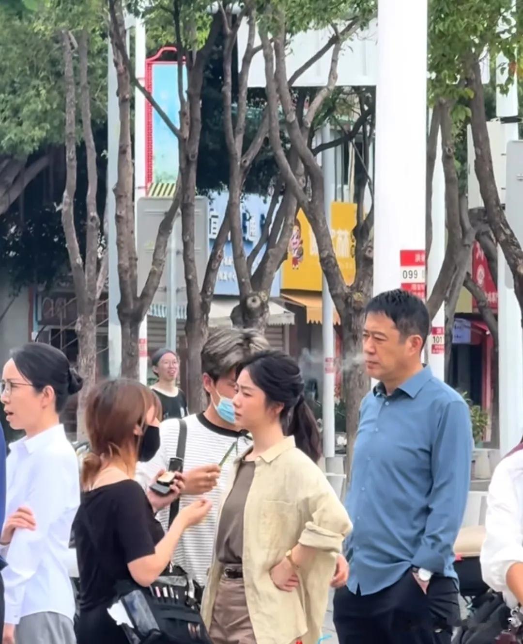演员刘钧和谭松韵拍戏，补妆等待间隙。只见刘钧拿着电子烟站在谭松韵身后一口一口抽的