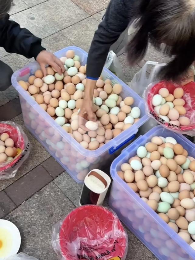 这样的老板注定要发财！卖鸡蛋的摊位前，一名男士笑着说：拿两个鸡蛋就拿吧，就当没