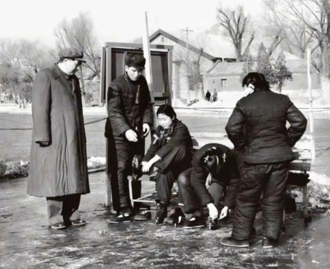 毛主席与孩子们的日常，像大多数父亲一样，李敏正在抬脚穿溜冰鞋，李讷低头系鞋带。