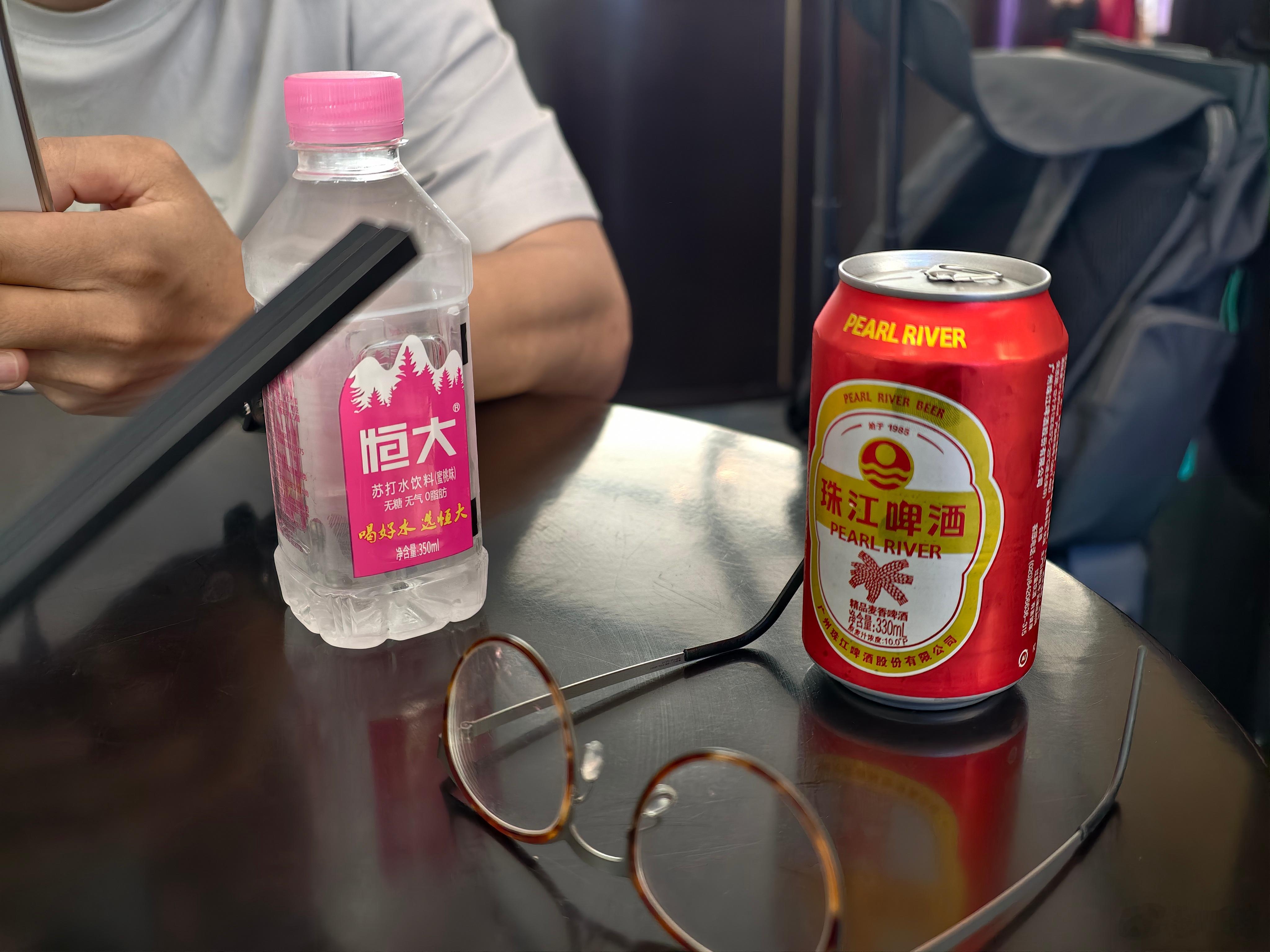 和在大兴机场“贵宾”休息室。他拿了一瓶恒大冰泉，粉色款。特丑。我拿了一瓶珠江啤酒