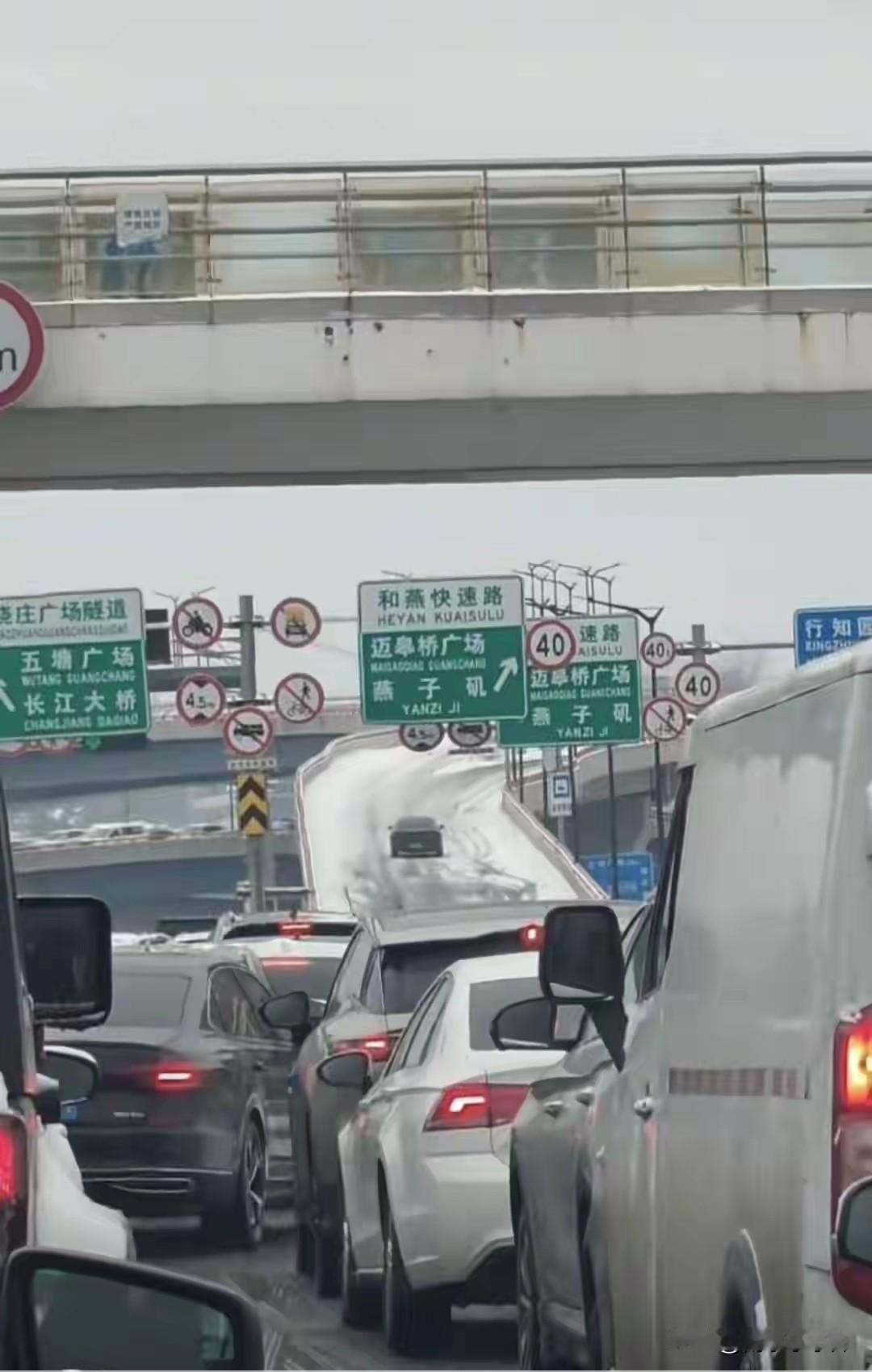 南京栖霞大道转和燕路匝道，车辆排着队被逐一放行。像驾考过单边桥一样。往年下雪