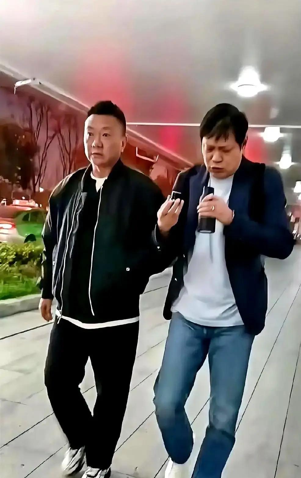 四川街头，范志毅和魏群一人一个保温杯，边走边聊，像两个遛弯的大哥。其实他们是来给